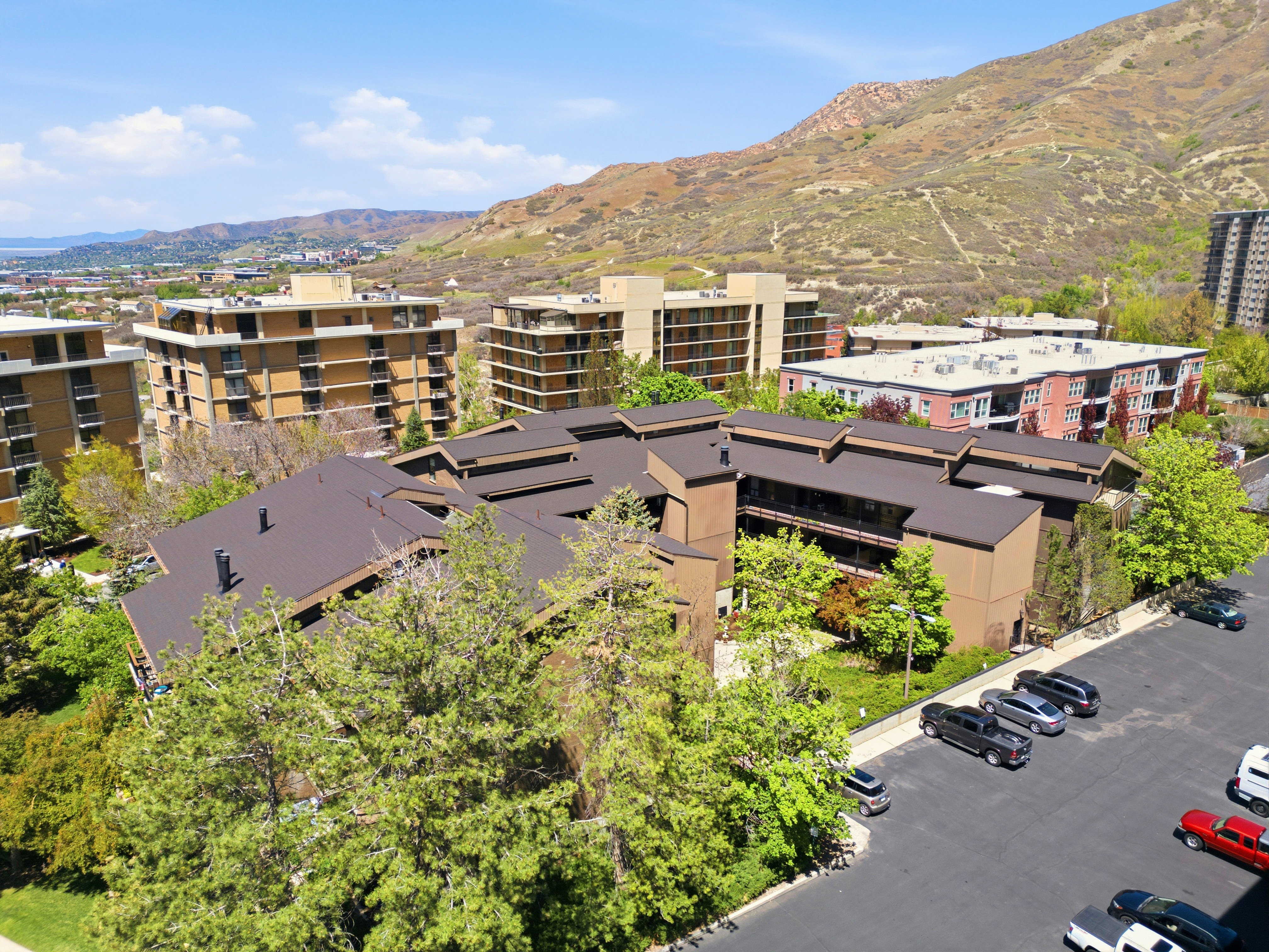 Multi-story residential building featuring a dark brown roofline and tan exterior