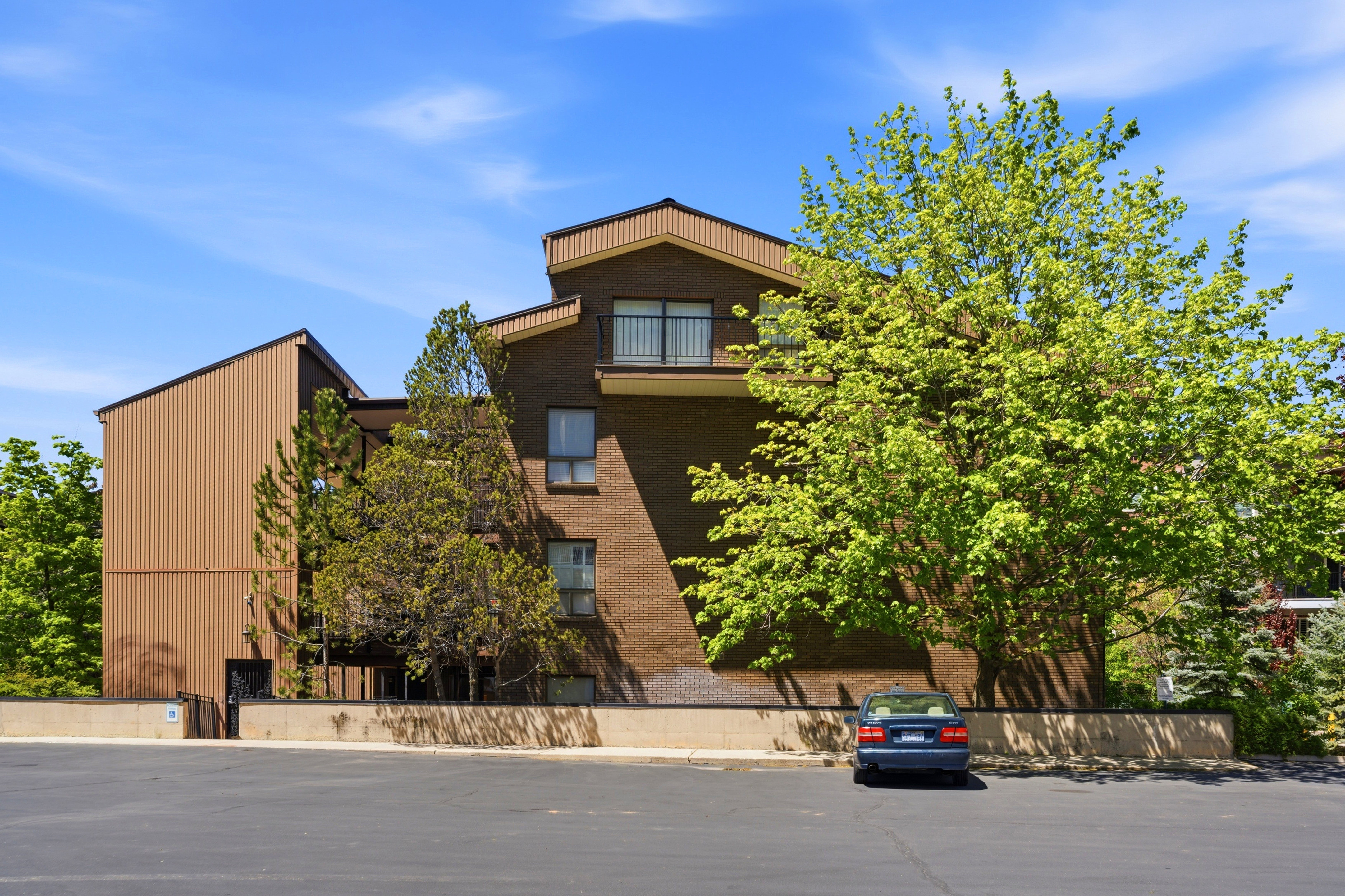 Multi-story building featuring a brick facade and vertical brown siding
