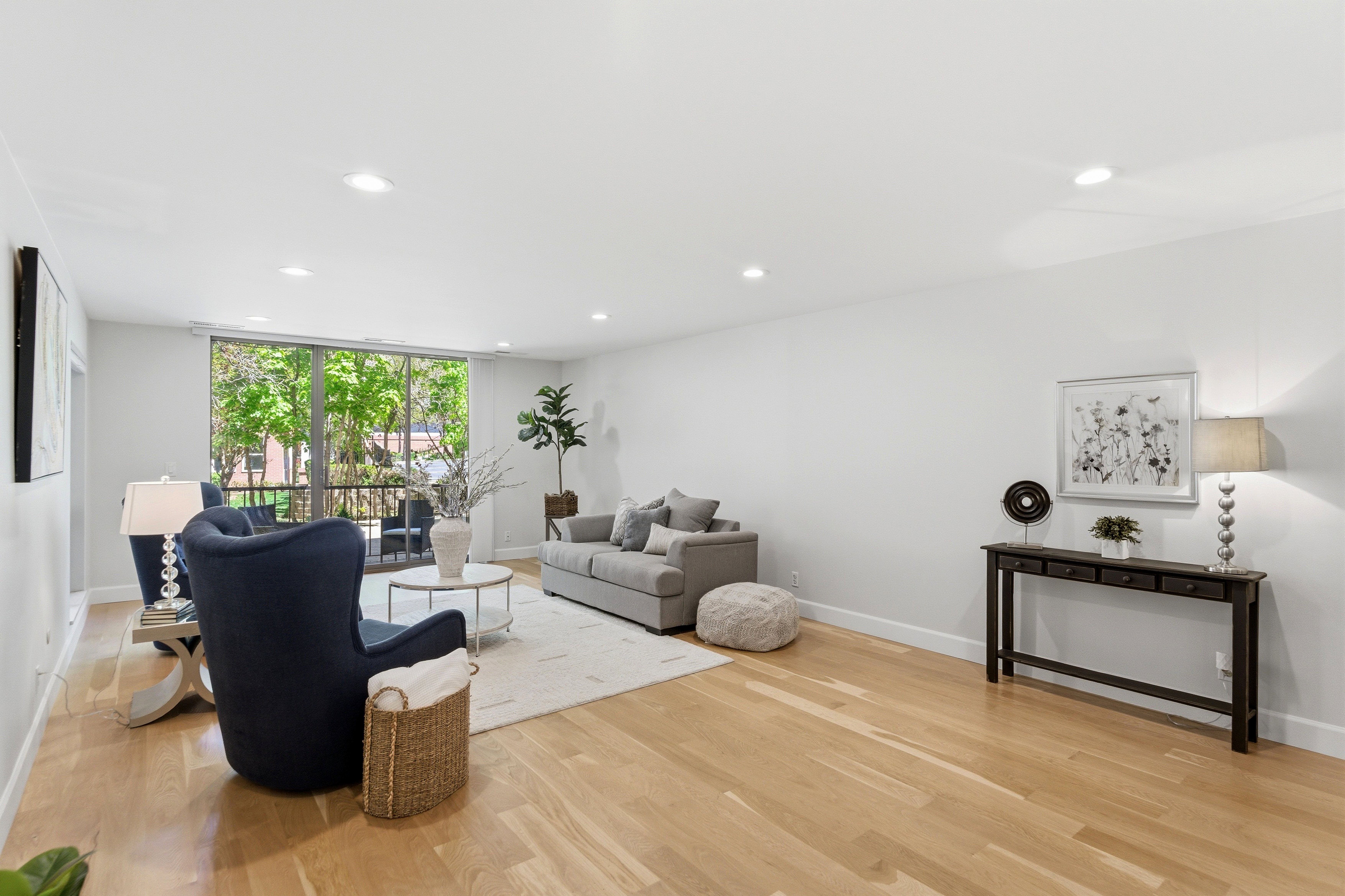 Spacious living area featuring light wood-finish flooring, recessed lighting, and expansive windows