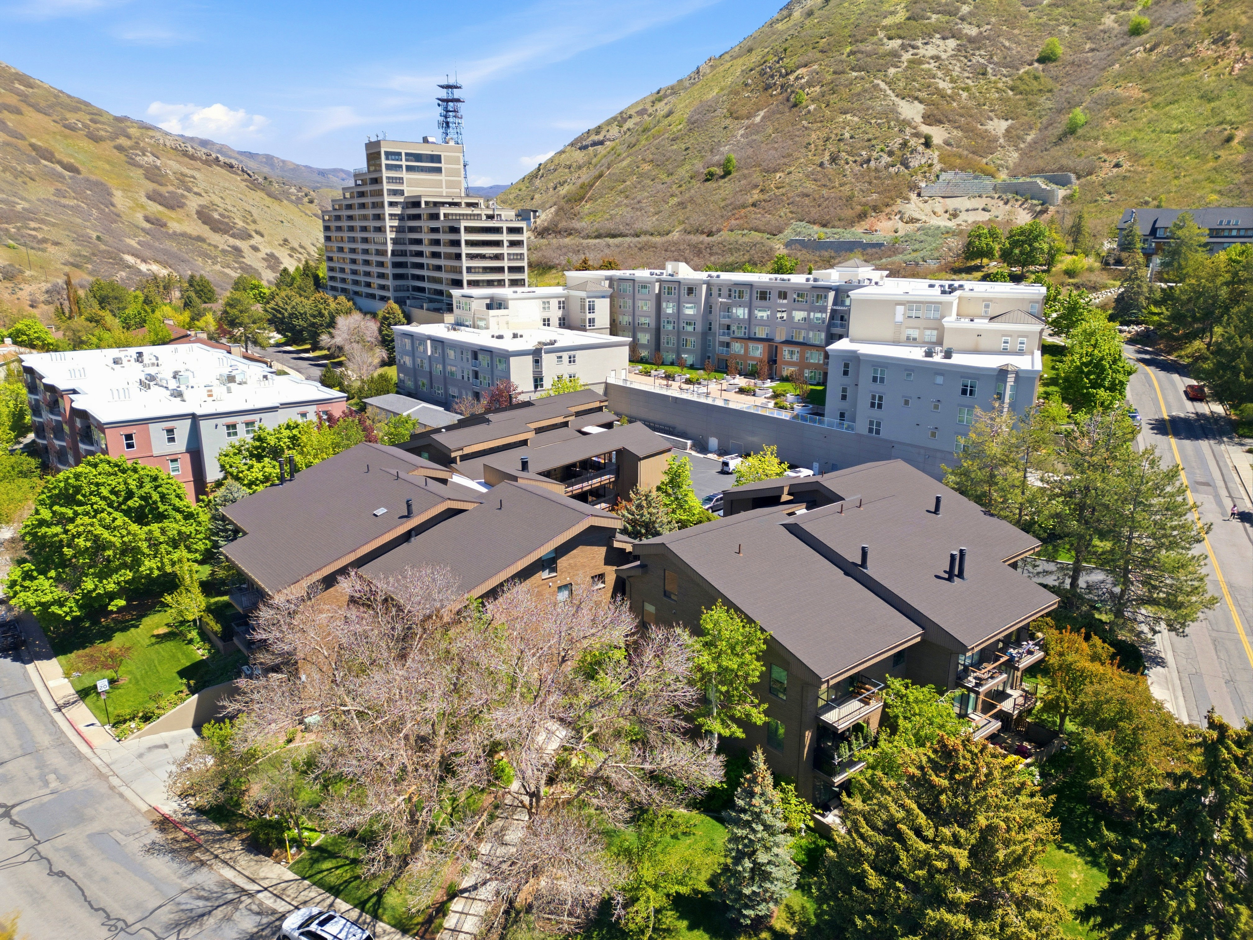 Aerial perspective of a multi-unit property featuring brown pitched roofs and multiple private balconies