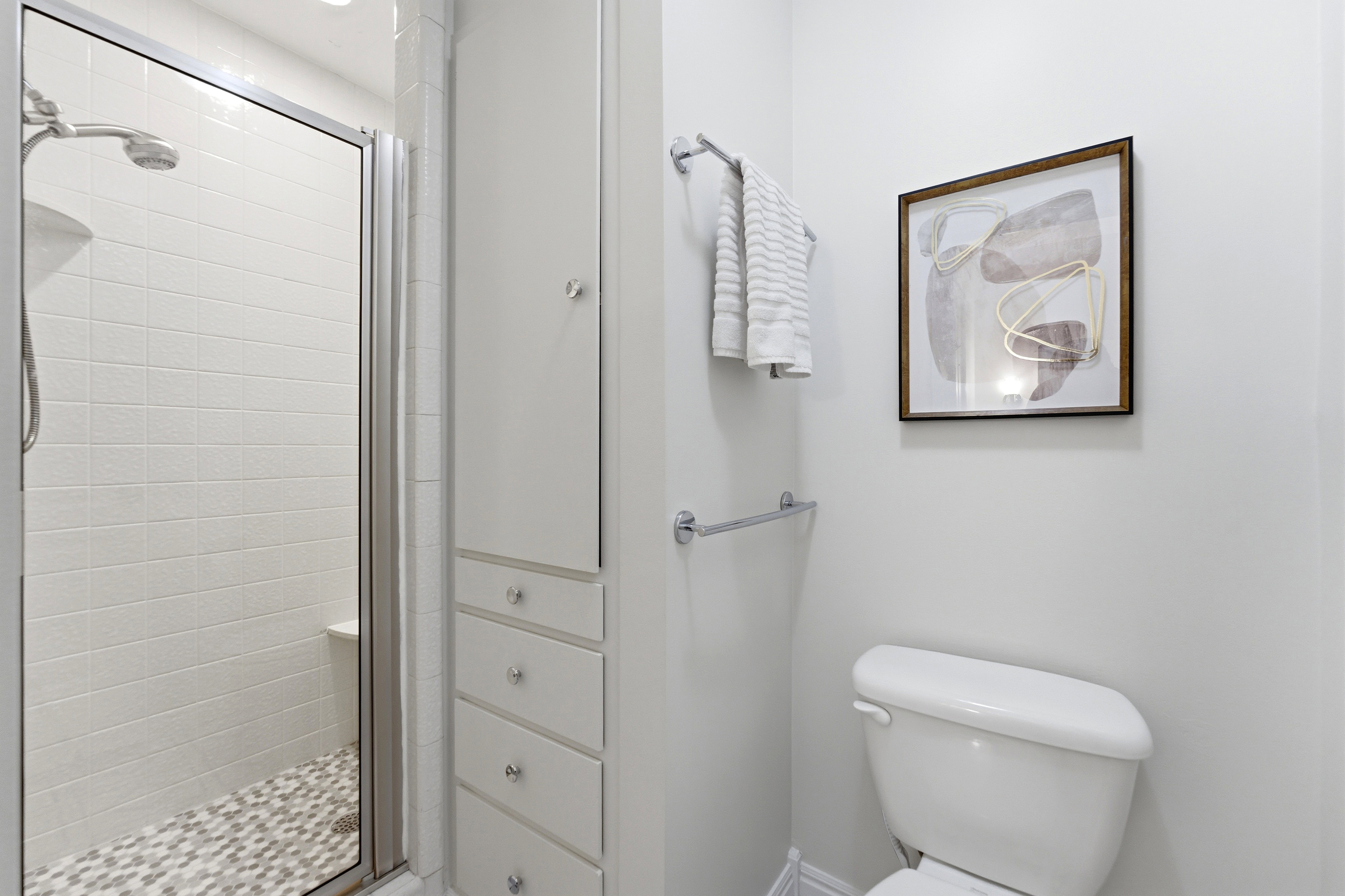 Enclosed shower with subway tile surround and mosaic tile flooring