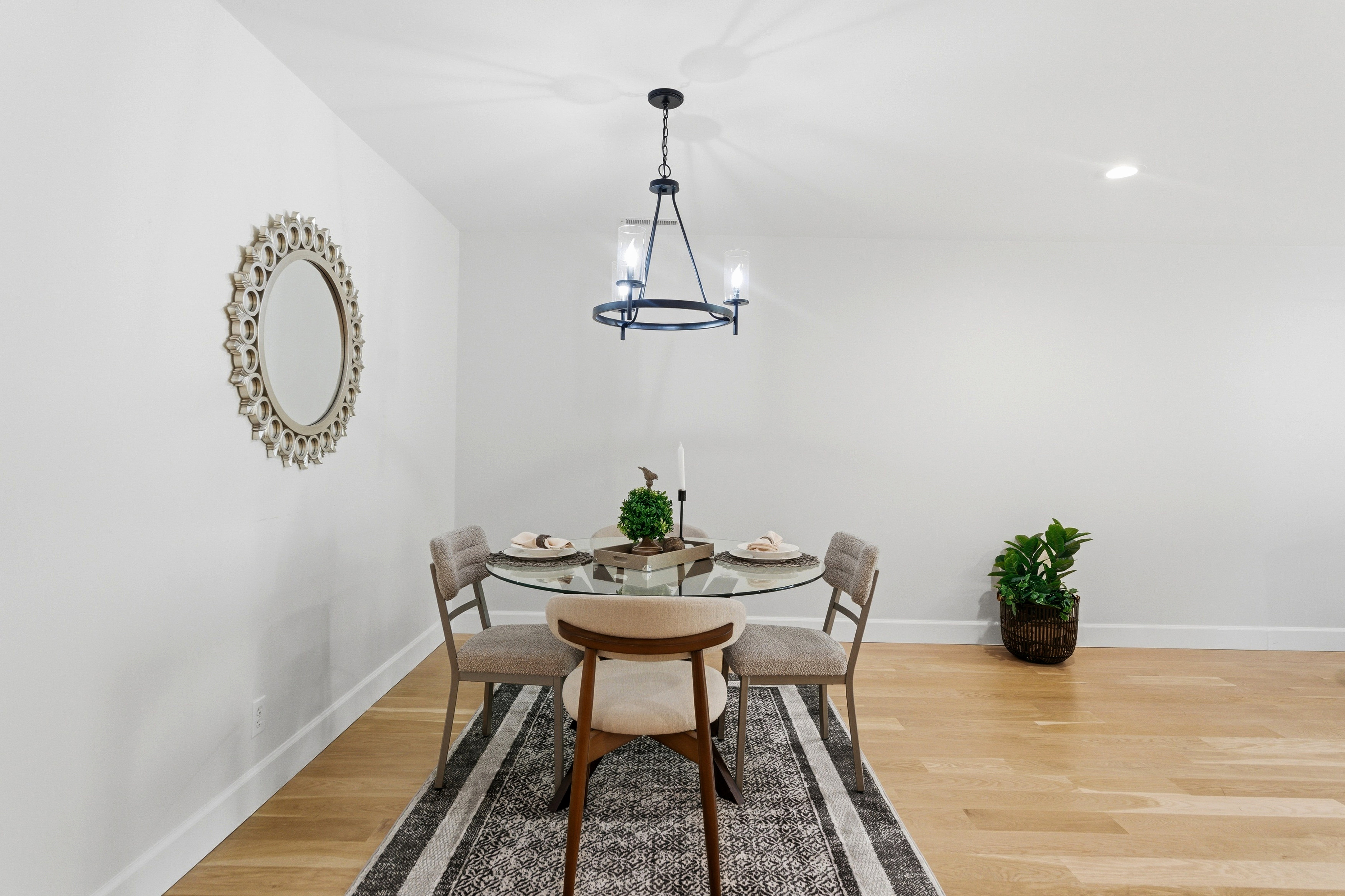 Dining area featuring a contemporary chandelier, light wood-finish flooring, recessed lighting, and crisp white walls
