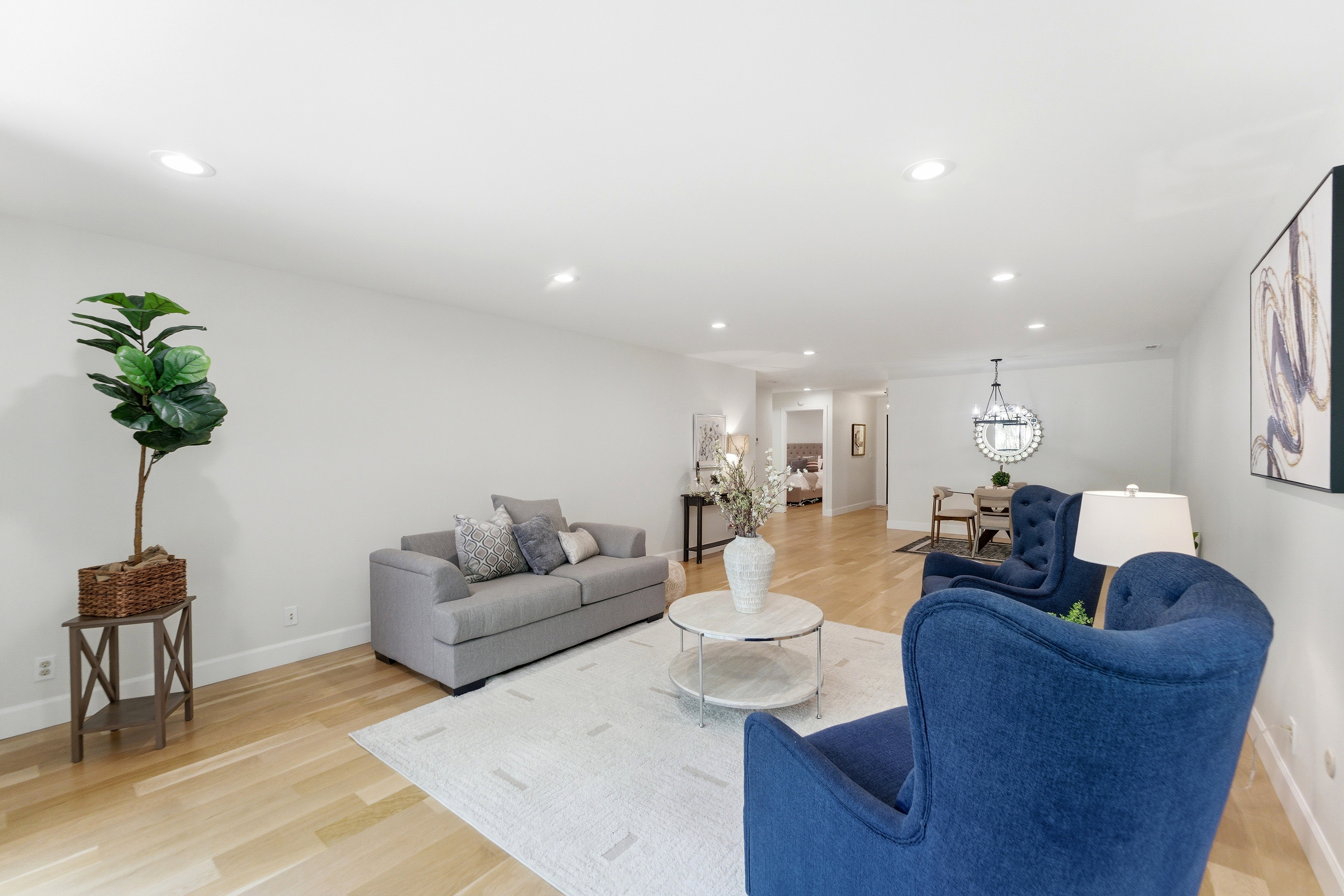 Bright living area featuring light wood-finish flooring, recessed lighting, and a neutral wall palette