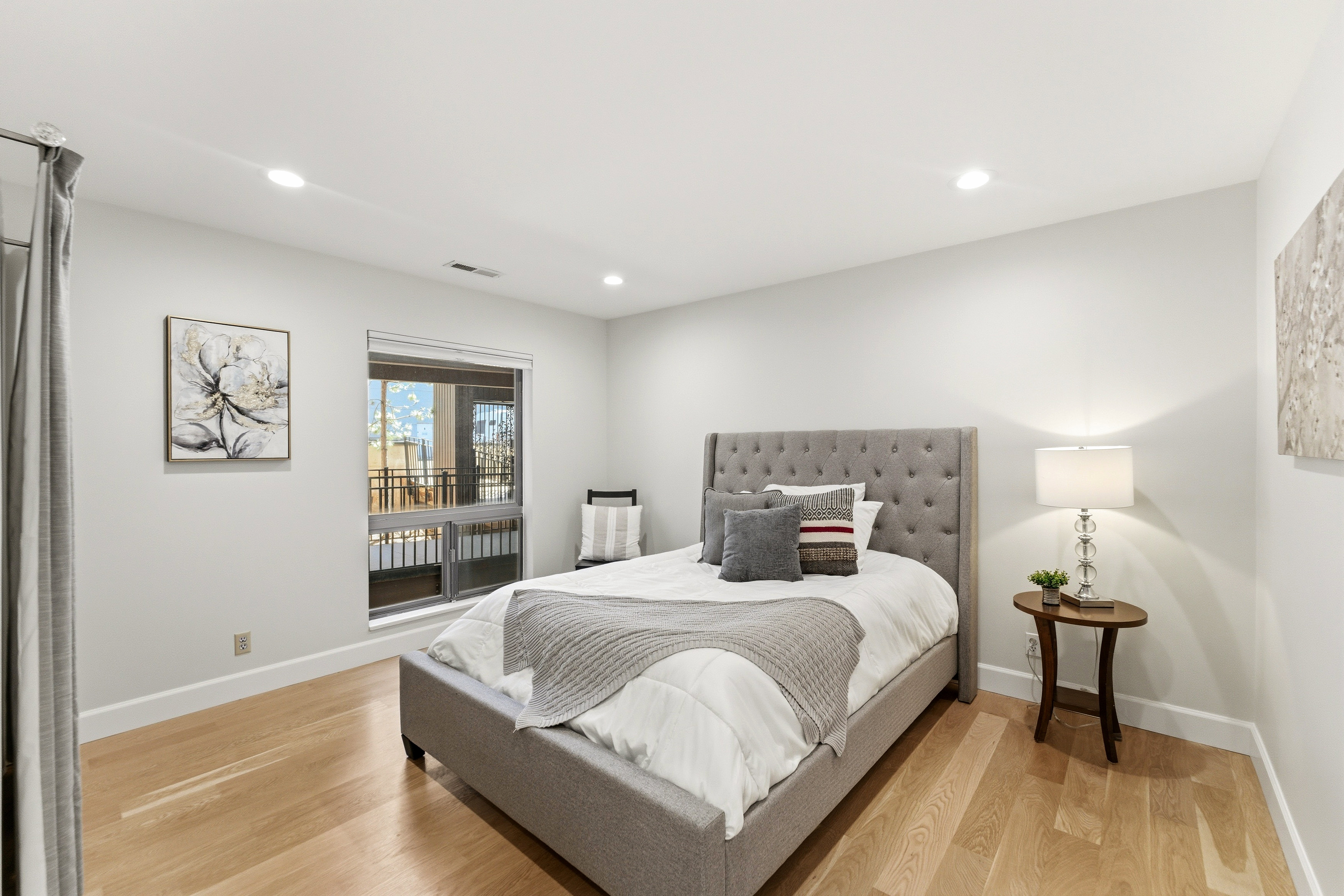Spacious room featuring light wood-finish flooring, recessed lighting, and a large window