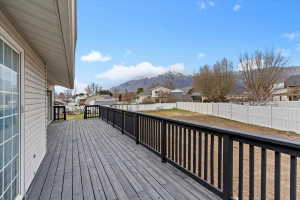 Expansive rear deck with dark wood-finish flooring and black railings