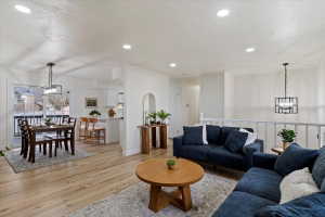 Open-concept living space featuring light wood-finish flooring, recessed lighting, and white walls