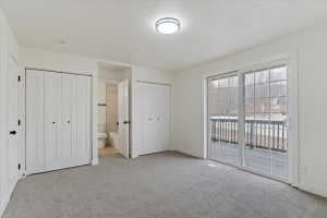 Spacious room featuring gray carpet, a ceiling-mounted light fixture, and white walls