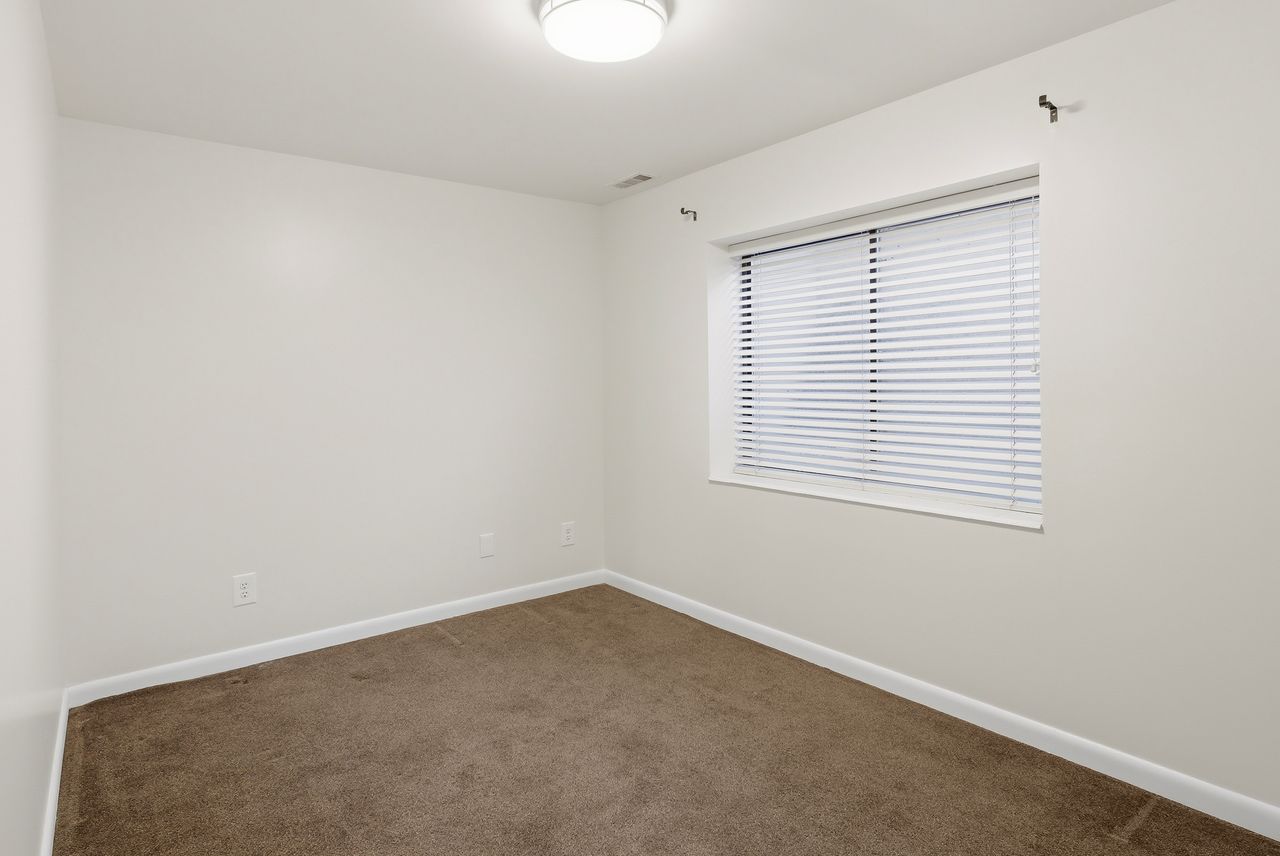 Unfurnished room with baseboards and dark carpet