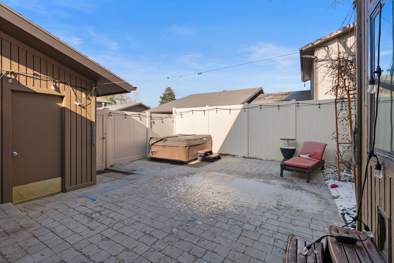 Fenced backyard featuring a patio, a hot tub, and a gate