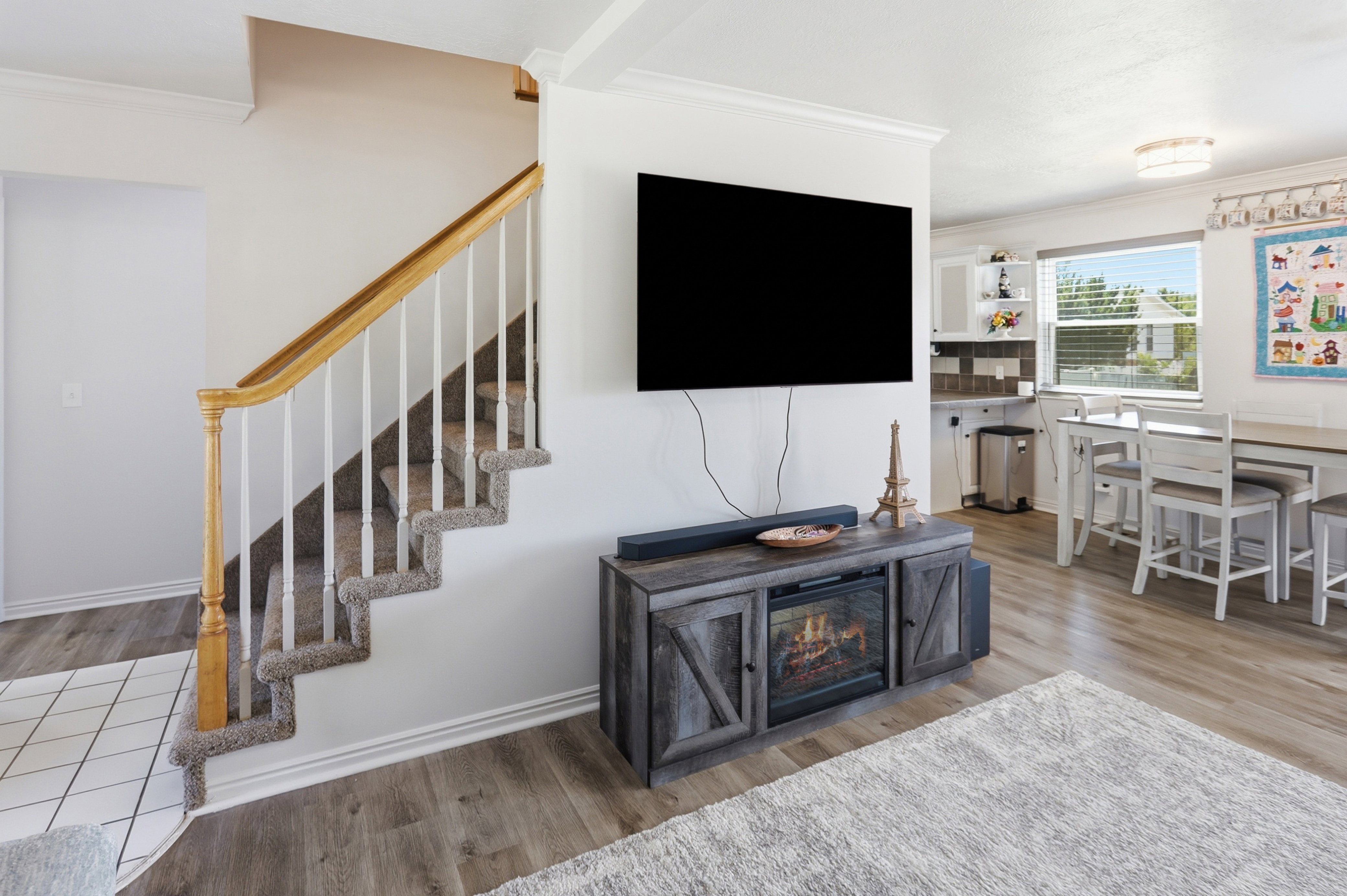 Carpeted staircase with a wood handrail and white balusters