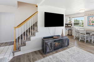 Carpeted staircase with a wood handrail and white balusters