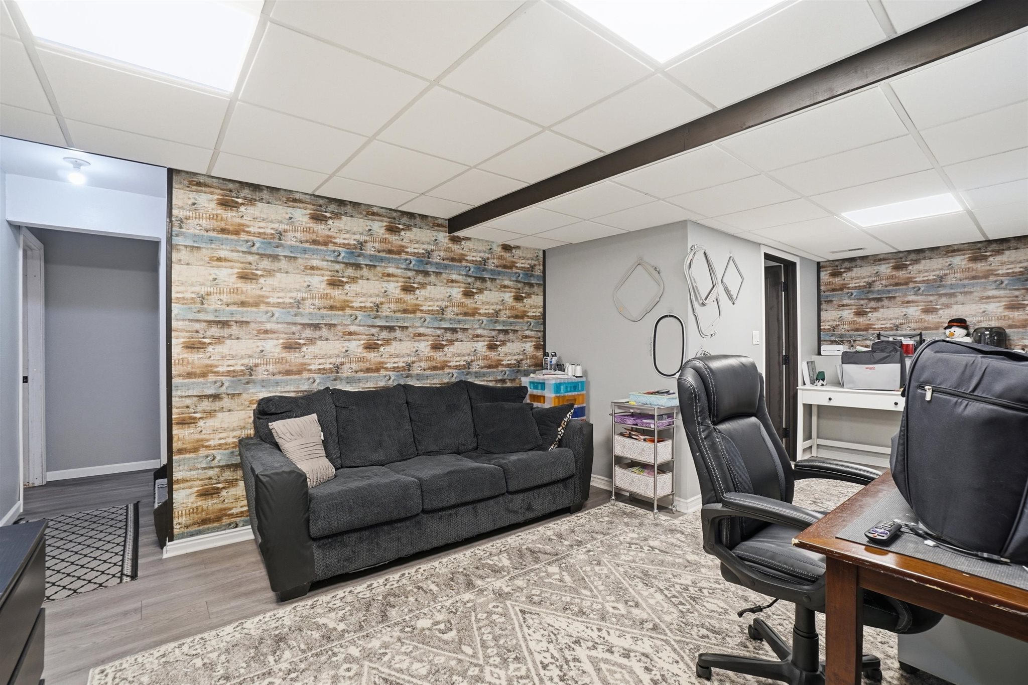 Spacious finished basement featuring wood-finish accent walls, recessed panel ceiling, and recessed lighting