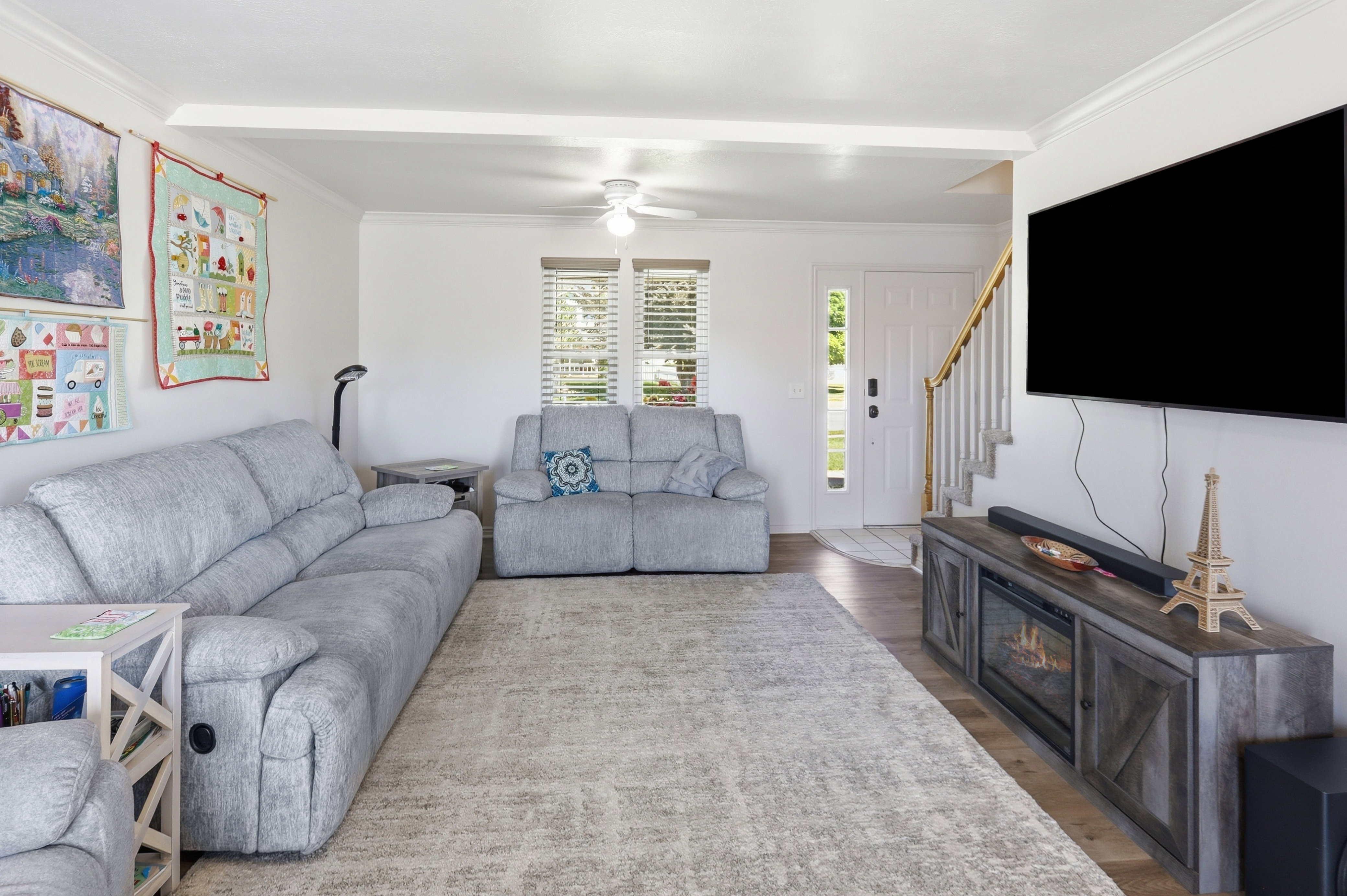 Spacious living area featuring light-colored walls and crown molding