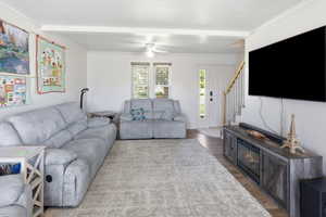 Spacious living area featuring light-colored walls and crown molding
