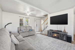 Spacious living area featuring light-toned walls and wood-finish flooring