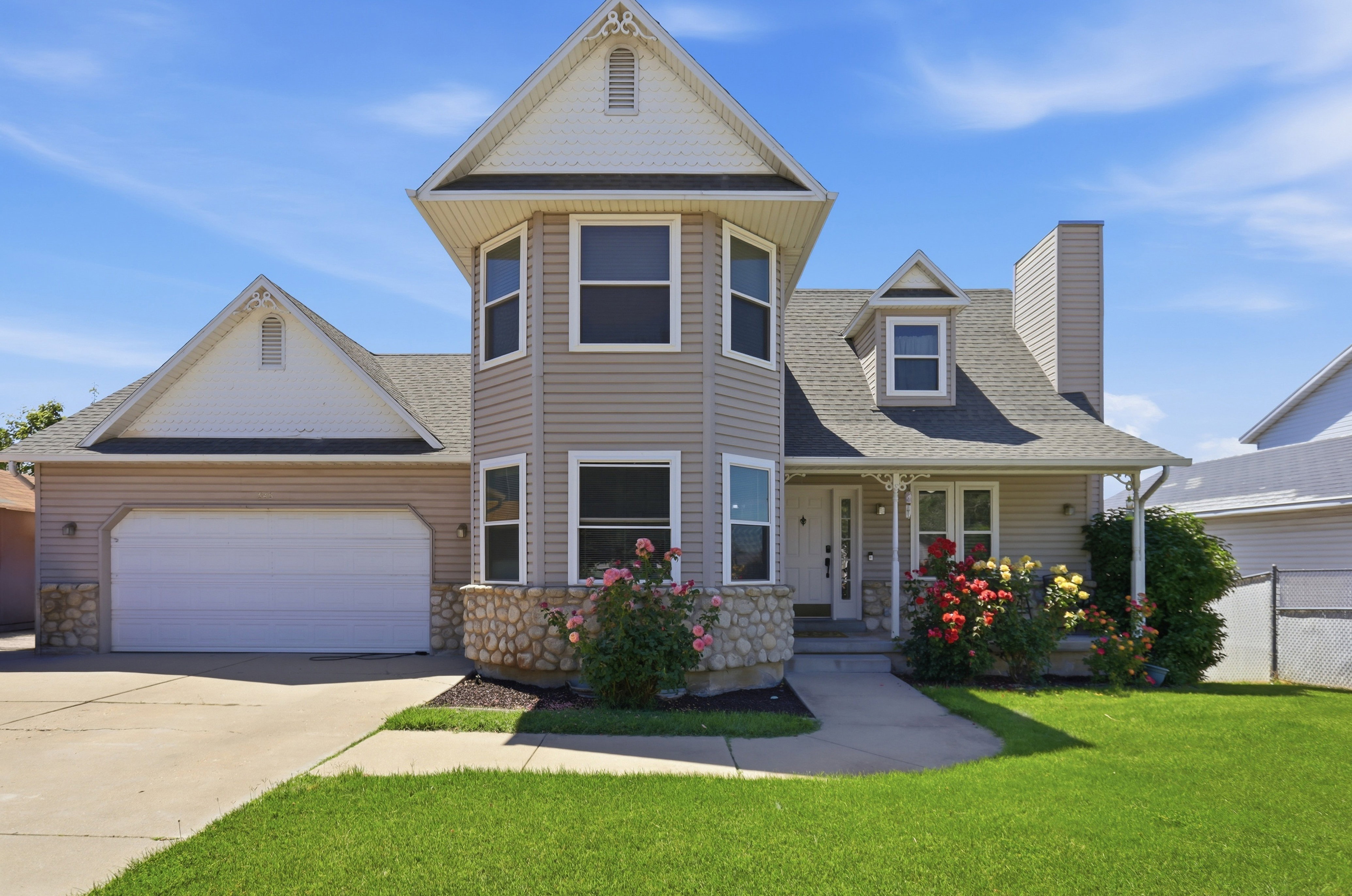 Traditional-style home featuring a two-story bay window tower and a covered front porch
