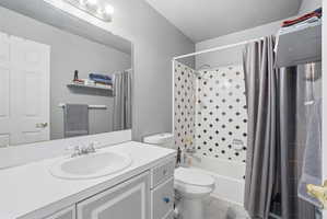 Bathroom featuring a white vanity with an integrated sink, a large wall-mounted mirror, and a three-bulb vanity light fixture