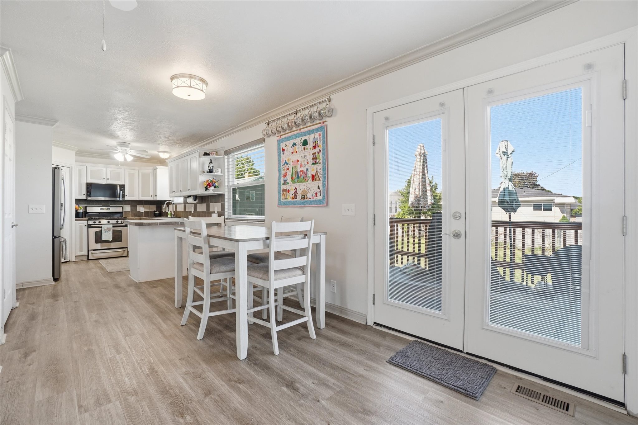 Bright kitchen and dining area featuring French doors leading to an outdoor deck