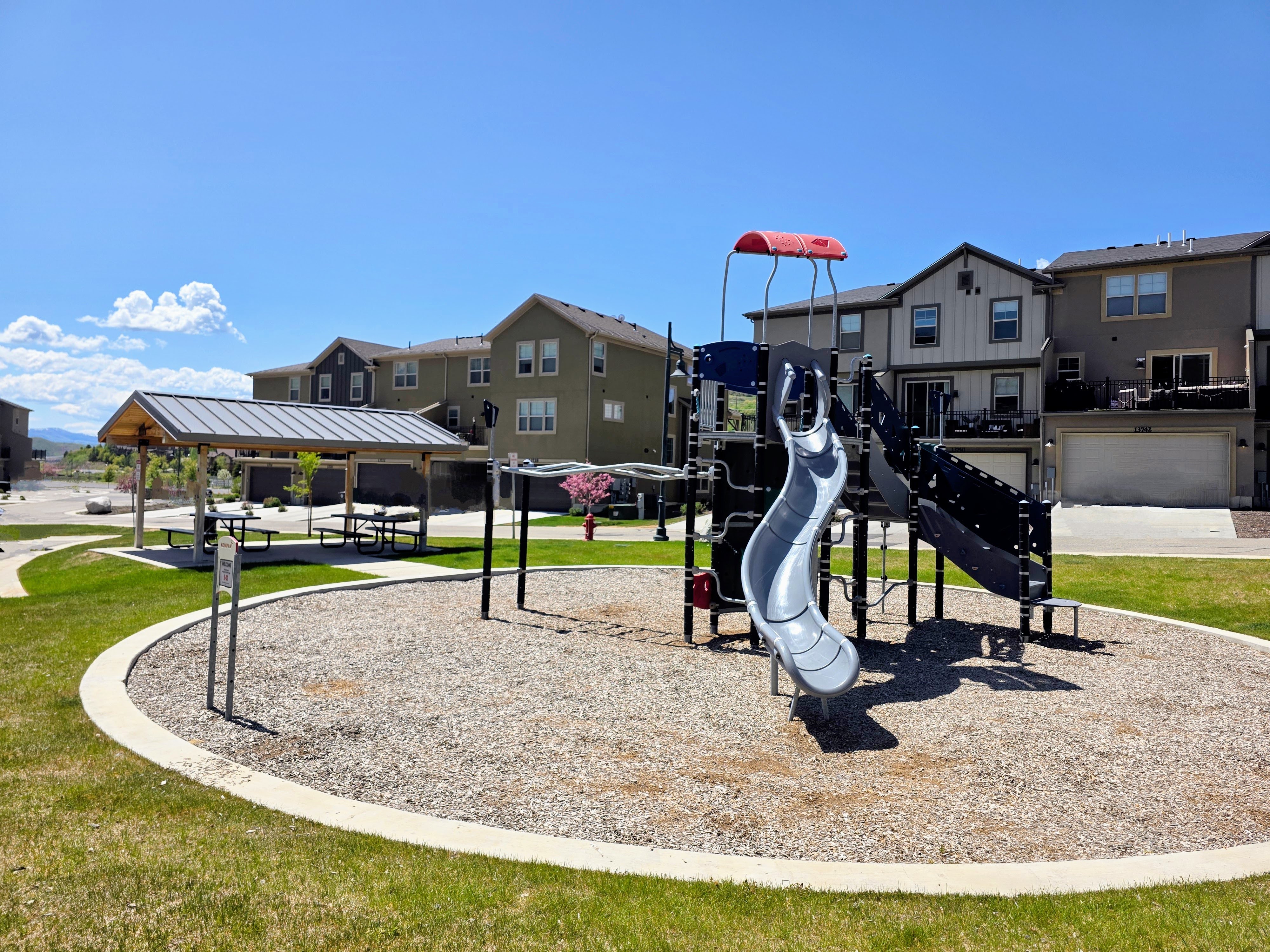 Community play area with a yard and a residential view