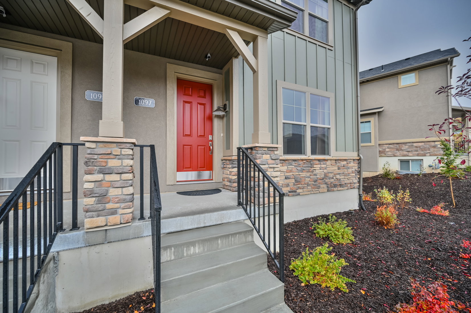 Entrance to property with board and batten siding, covered porch, and stone siding
