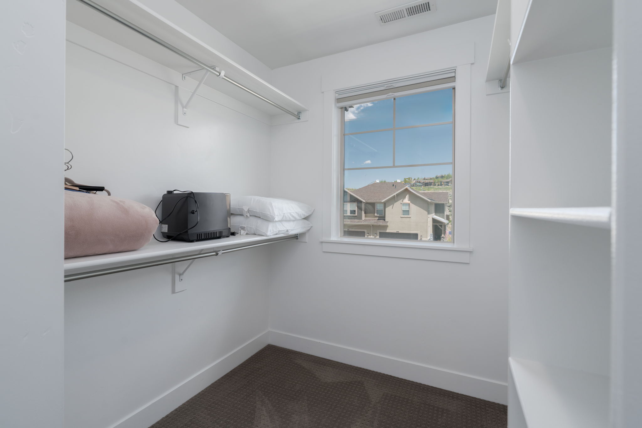 Walk in closet with dark carpet