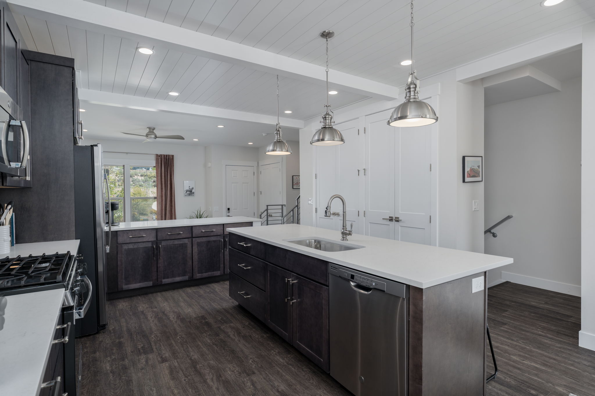 Kitchen featuring stainless steel appliances, dark wood finished floors, dark wood finish cabinets, and a wood ceiling with exposed beams