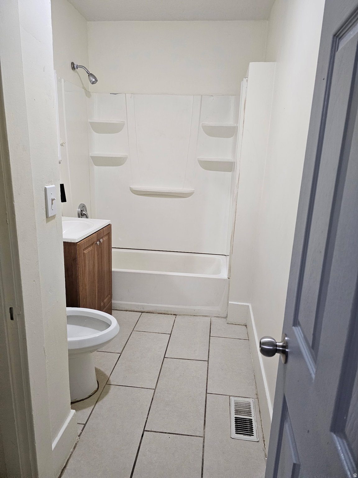 Bathroom featuring vanity, light tile patterned flooring, and tub / shower combination