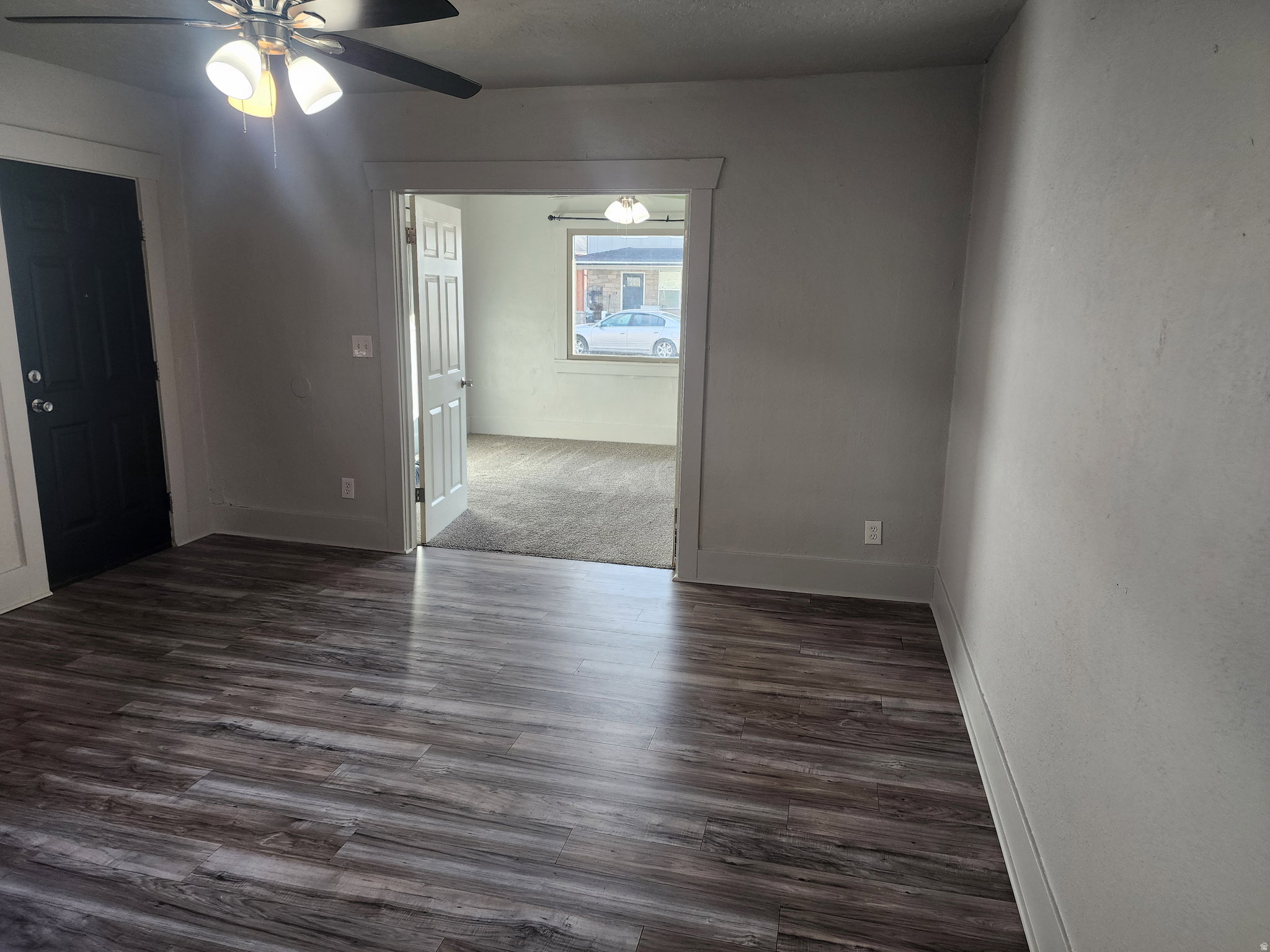 Unfurnished room with ceiling fan and dark wood-style flooring