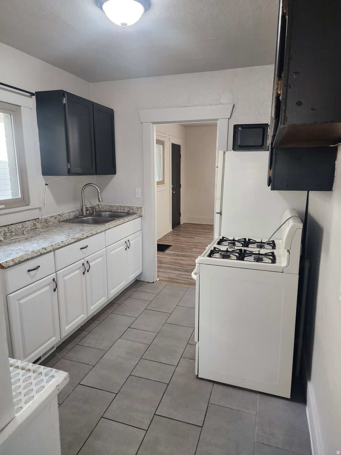 Kitchen with white appliances, light countertops, and light tile patterned floors