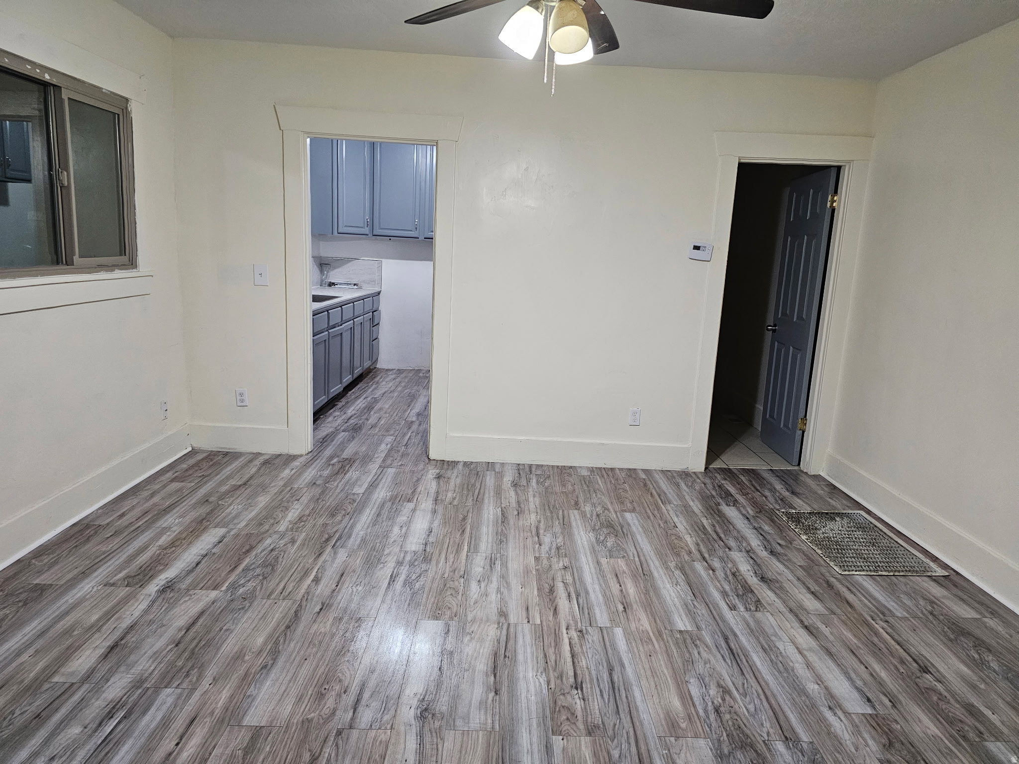 Empty room with ceiling fan and light wood-style flooring