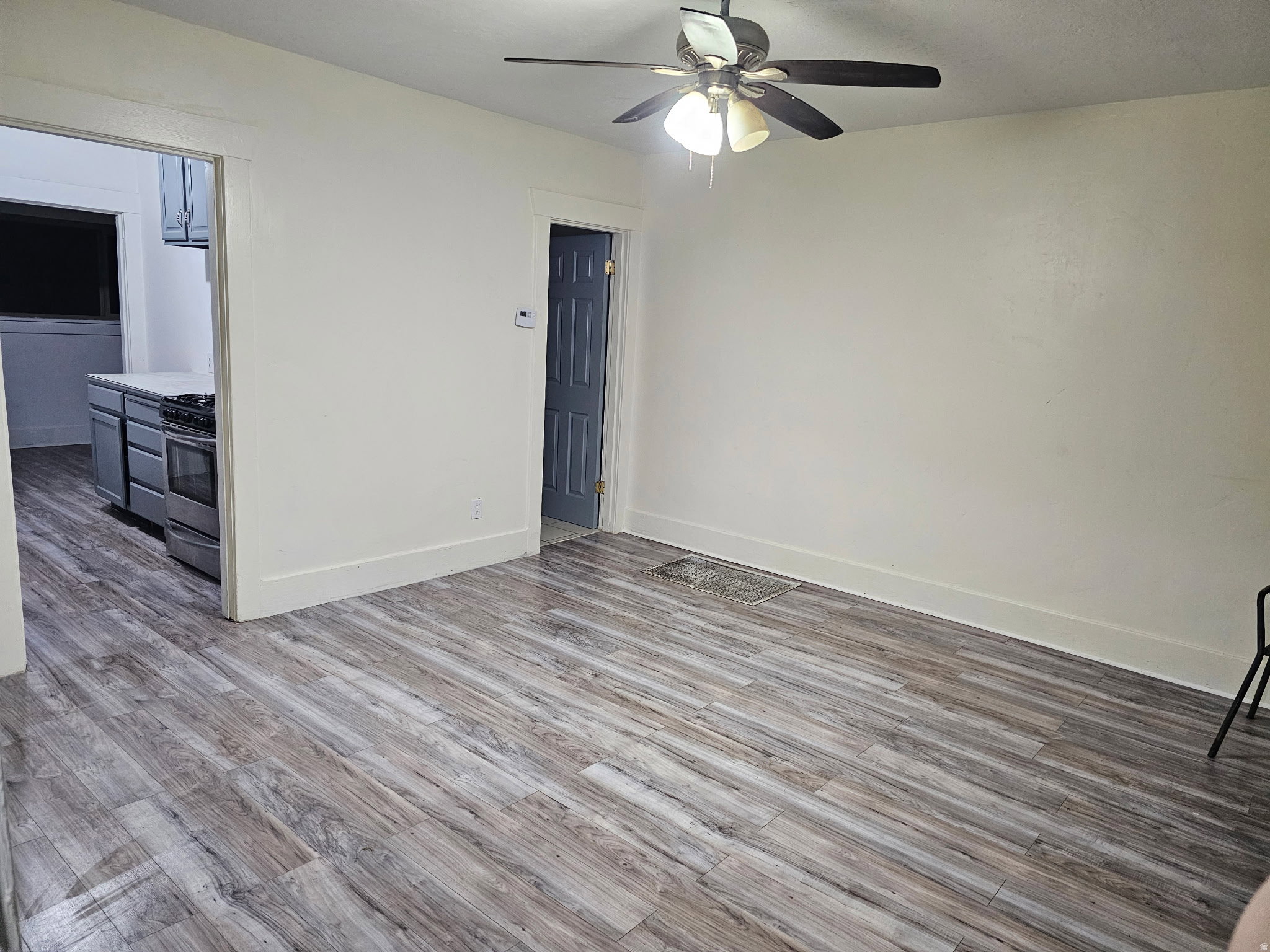 Unfurnished living room with light wood-style floors and a ceiling fan