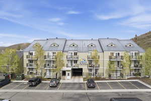 View of apartment building / complex with a mountain view and uncovered parking