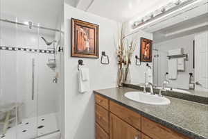 Bathroom featuring vanity and a shower stall
