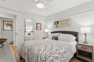 Bedroom with light wood-type flooring, ceiling fan, and a baseboard radiator