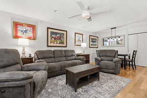 Living area with wood finished floors and ceiling fan