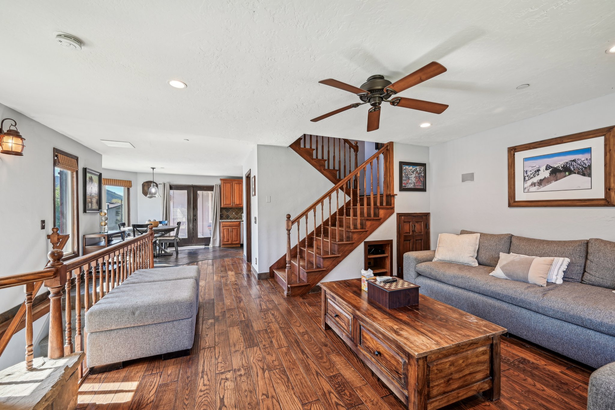 Living room with dark wood-type flooring, ceiling fan, and recessed lighting