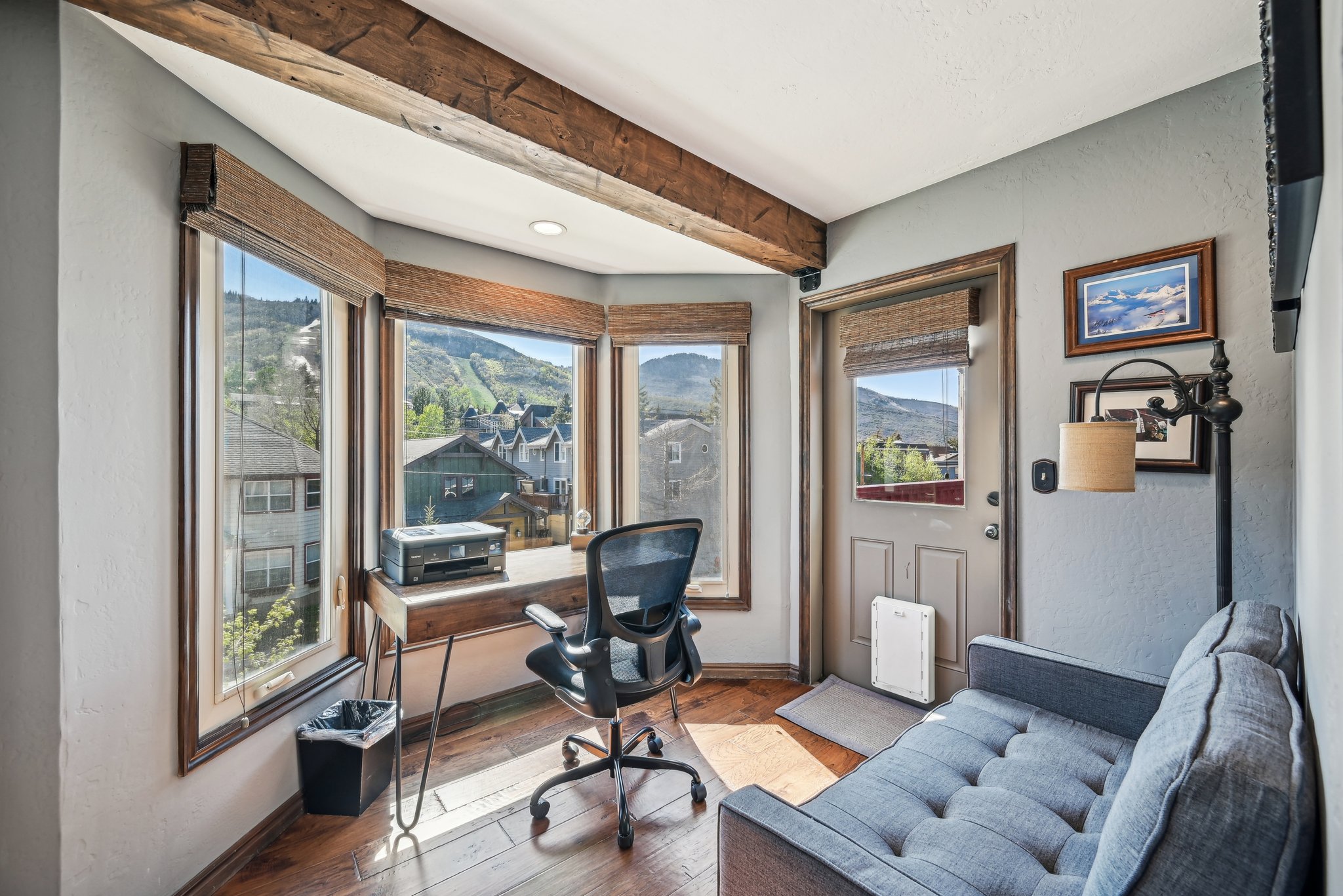 Office area with a textured wall, hardwood / wood-style flooring, a mountain view, and beamed ceiling
