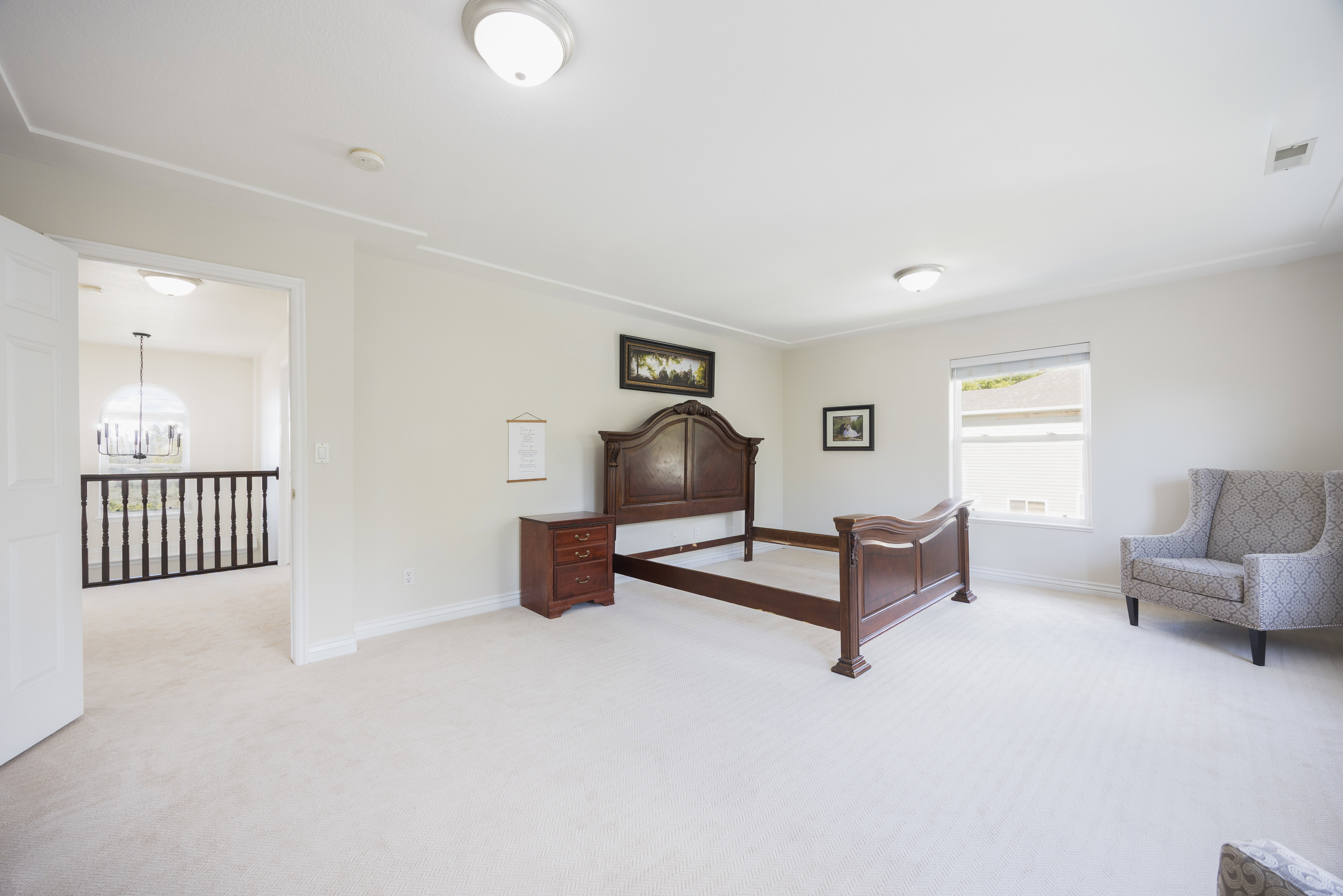 Spacious carpeted room featuring crown molding, a large window with blinds, and flush mount lighting