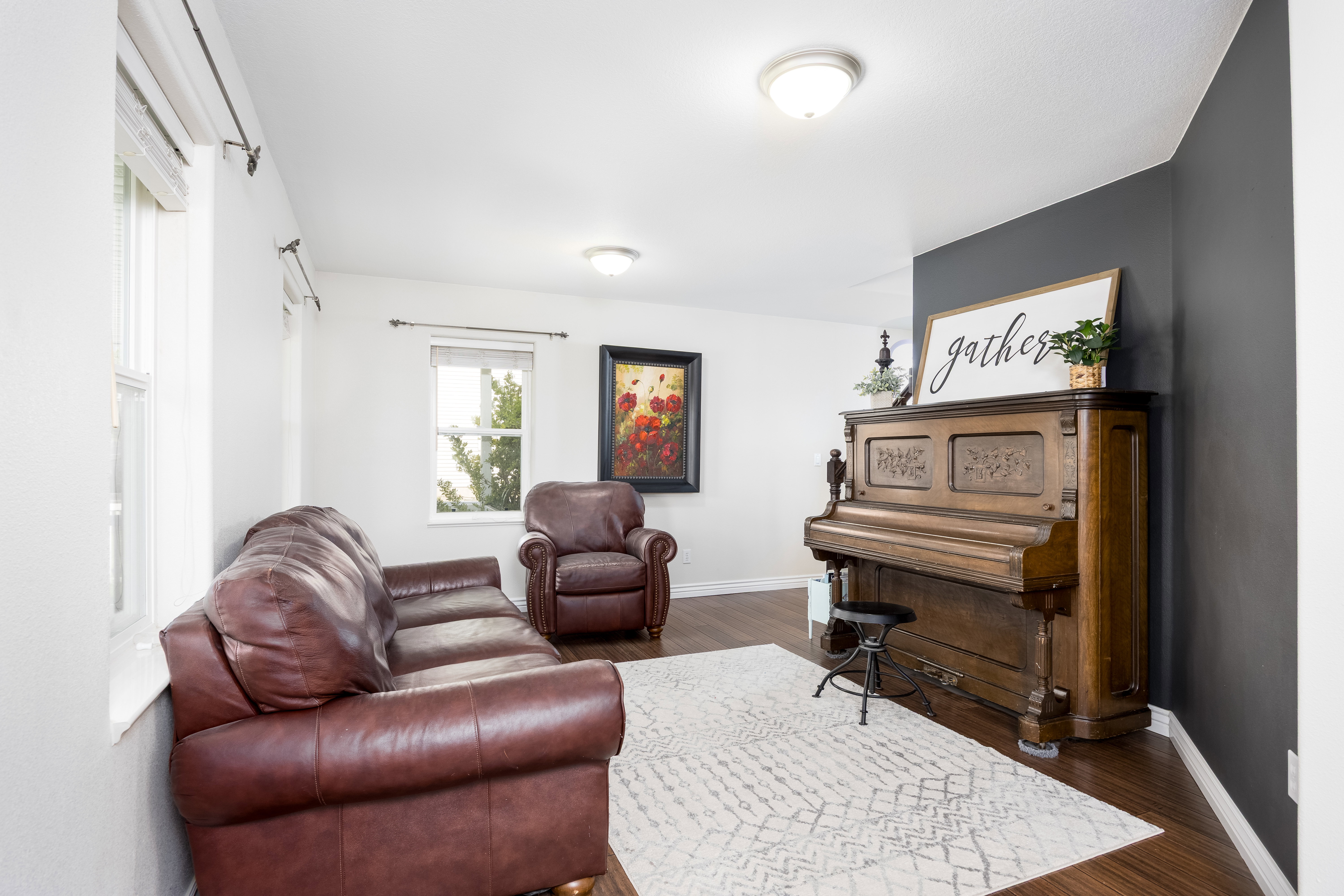 Bright room featuring wood-finish flooring, white walls, and a contrasting dark accent wall