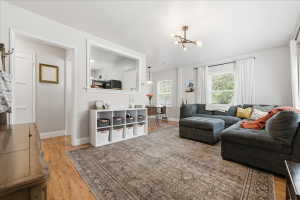 Living room with light wood-style floors and a chandelier
