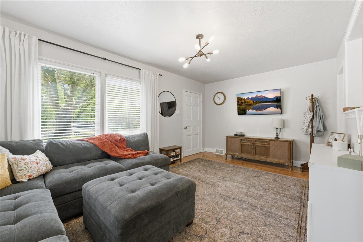 Living area with wood finished floors and hanging lights