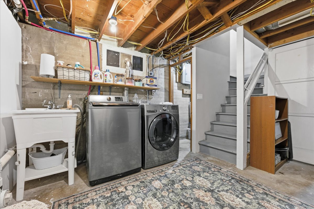 Laundry area featuring unfinished concrete flooring and washing machine and dryer