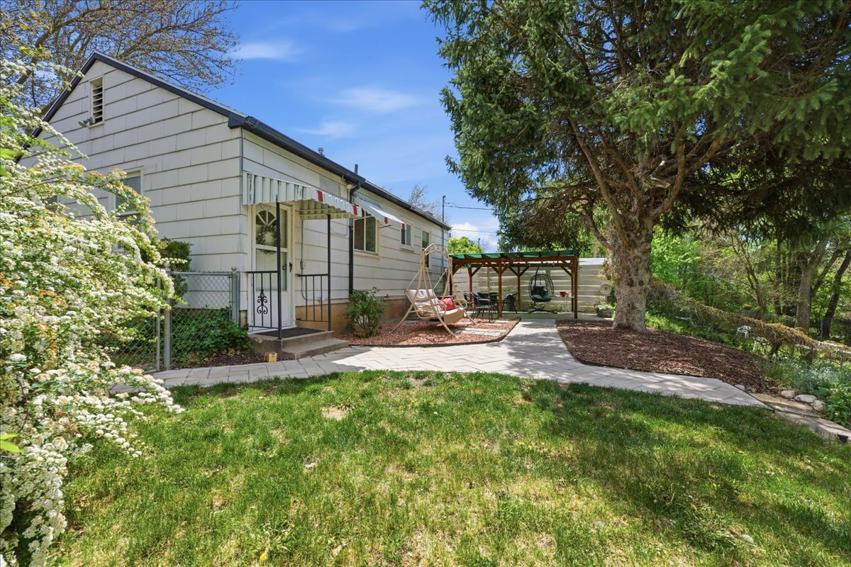 Rear view of property featuring a pergola and a gate
