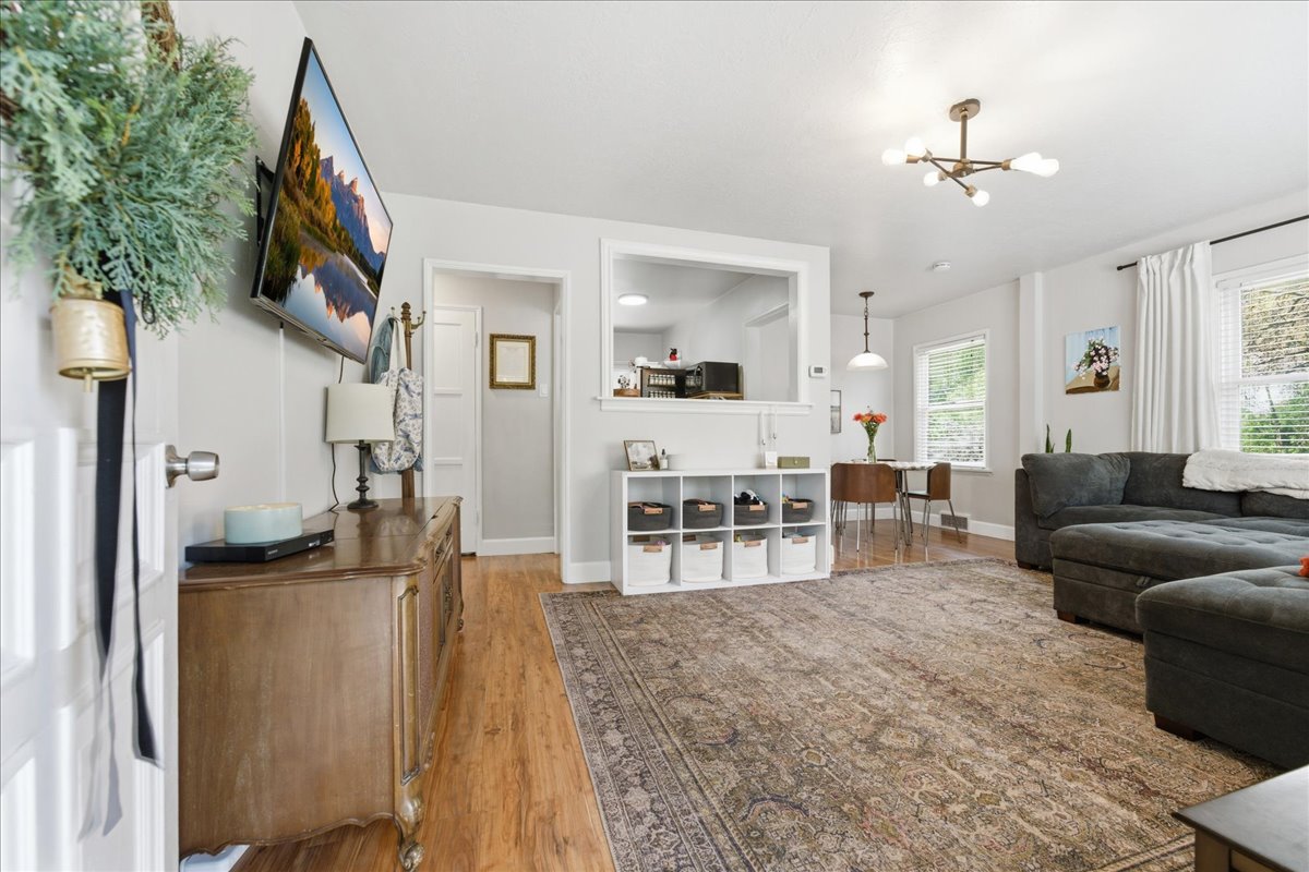 Living room with light wood-type flooring and a chandelier
