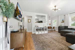 Living room with light wood-type flooring and a chandelier
