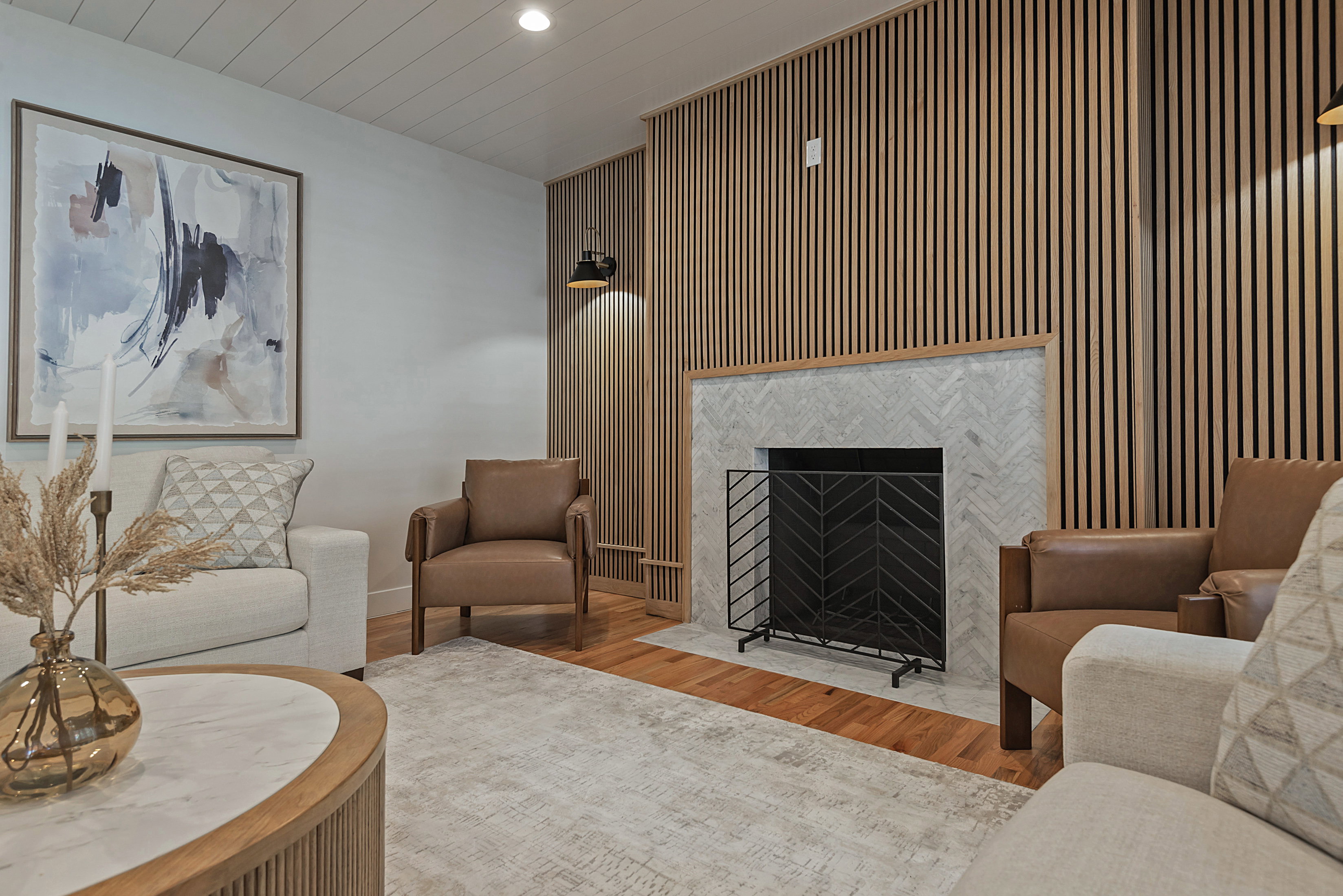 Living room with wood floors, a fireplace, recessed lighting, and wood accent walls