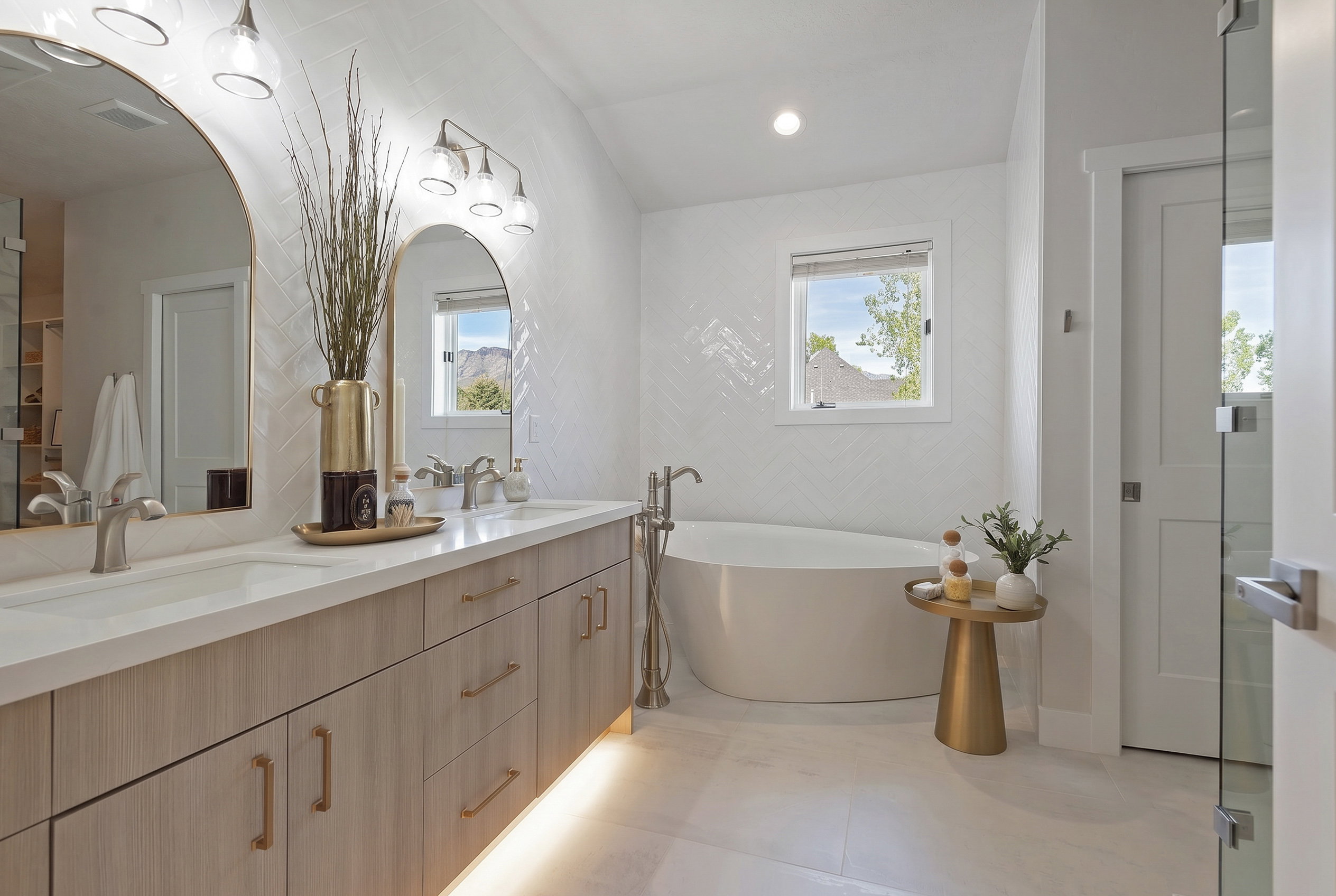 Full bath featuring double vanity, a soaking tub, healthy amount of natural light, and recessed lighting