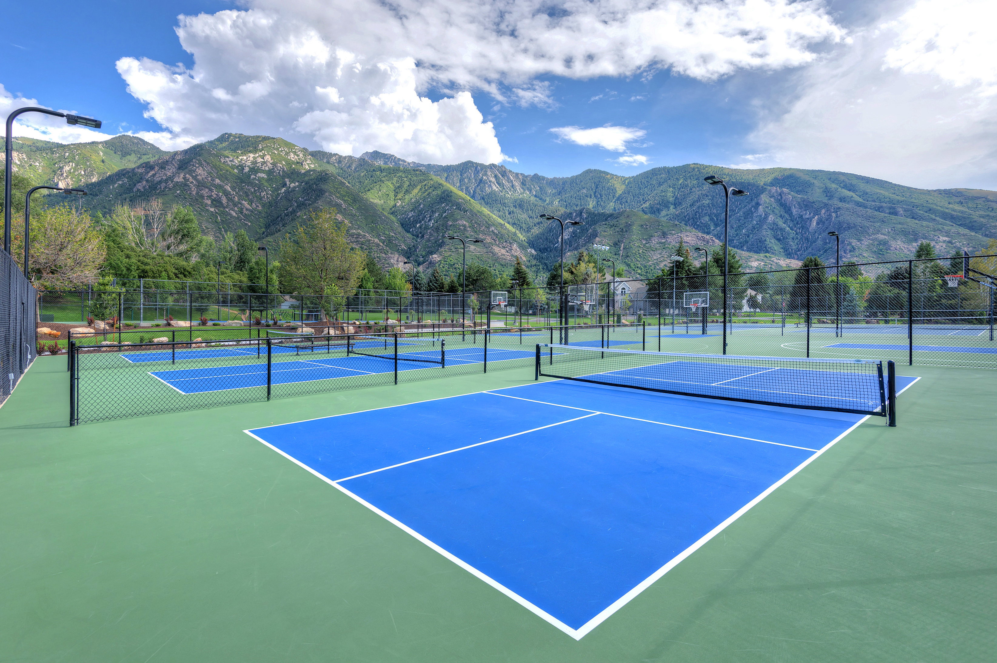 View of tennis court featuring a mountain view and community basketball court