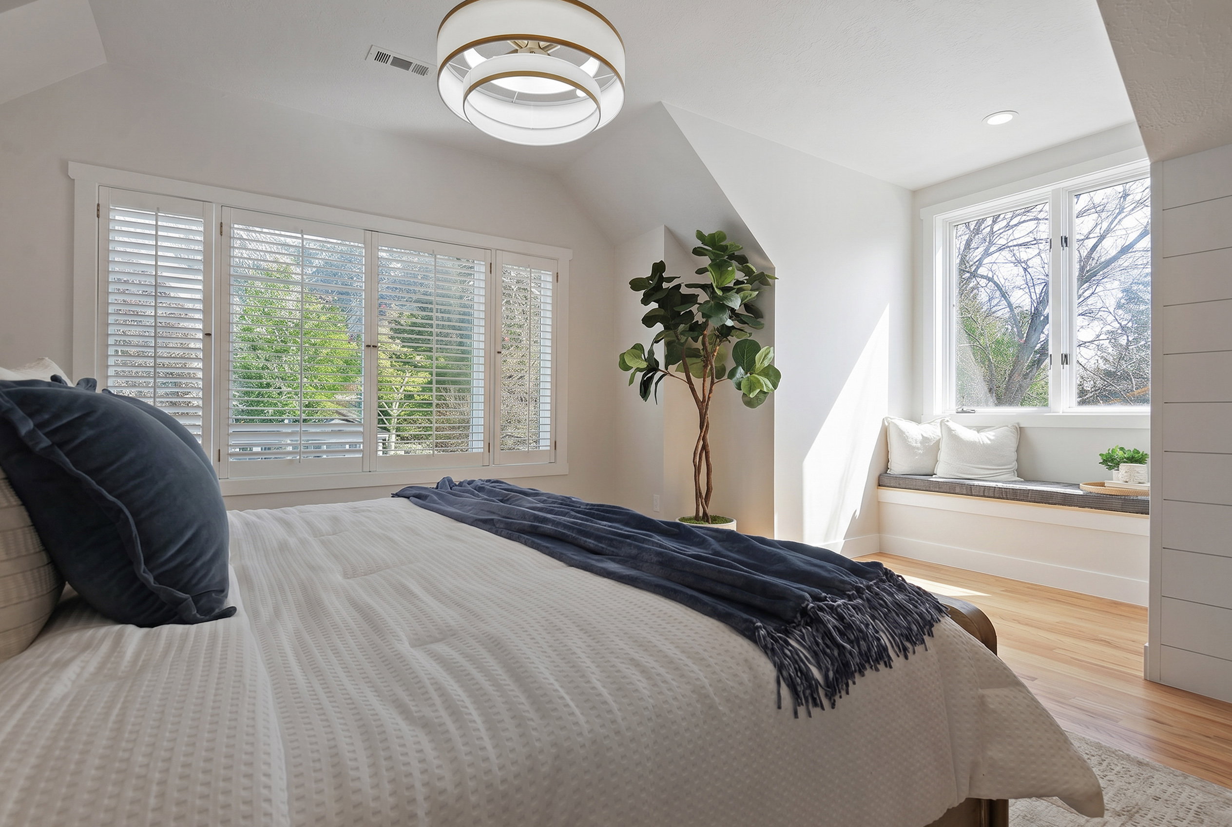 Oversized En suite primary Bedroom featuring vaulted ceiling, multiple windows, and bench seating.