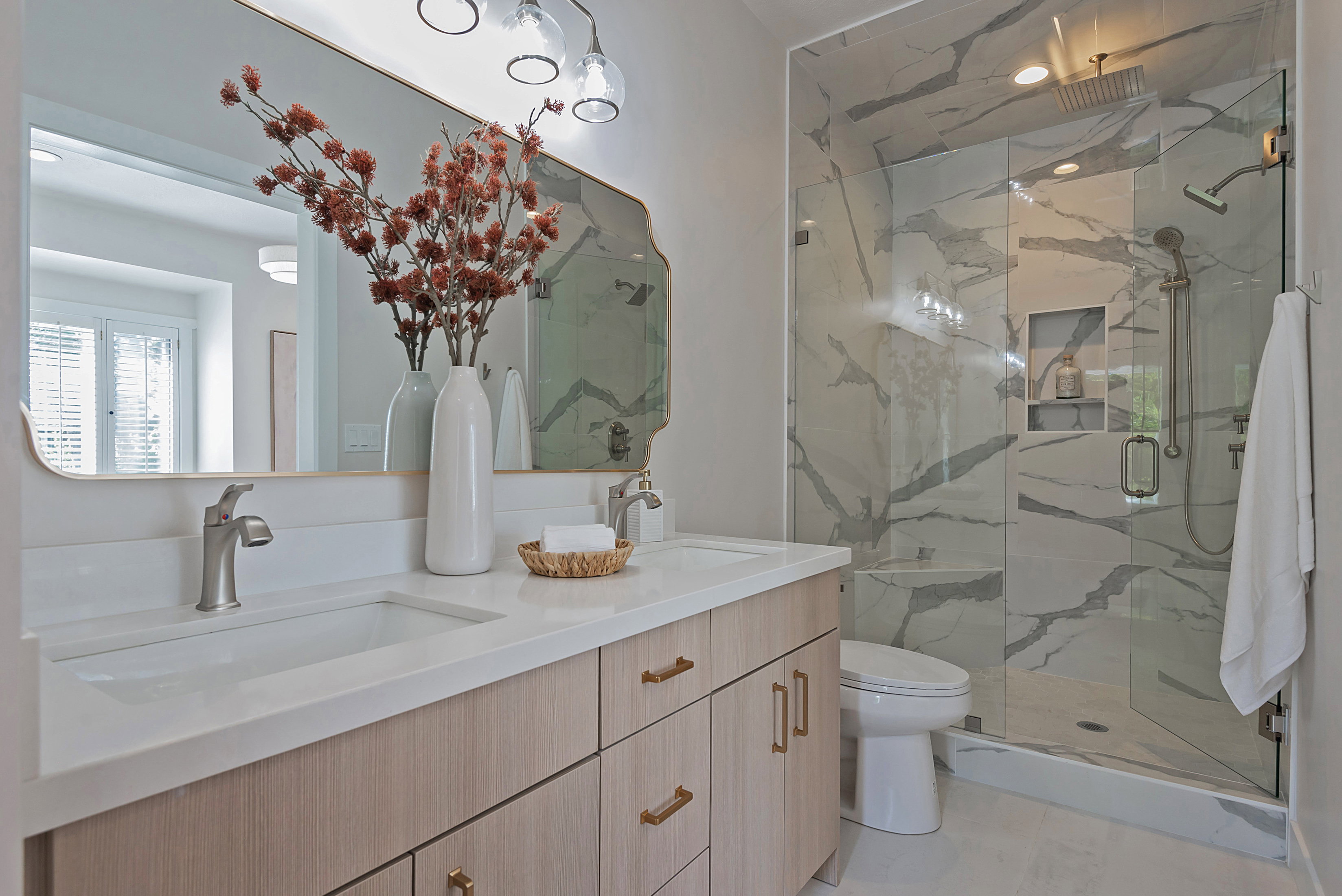 Ensuite Bathroom featuring double vanity and a marble finish shower with 2nd laundry
